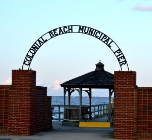 A wrought iron sign that says Colonial Beach Municipal pier graces the entrance to the town's pier